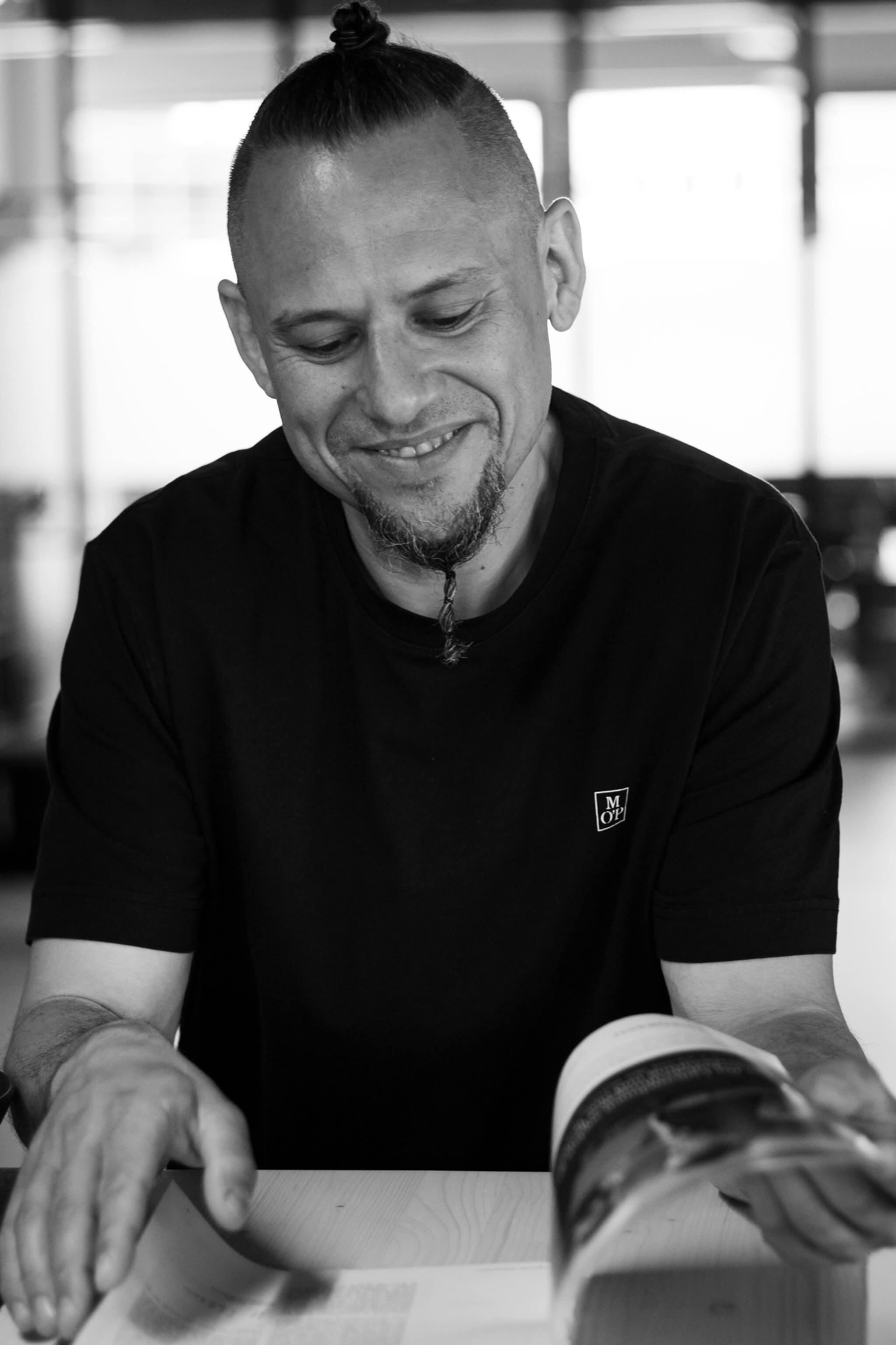 Andreas Schmitz Andreas Schmitz, der in einer Zeitung blättert, runter schaut und lächelt.